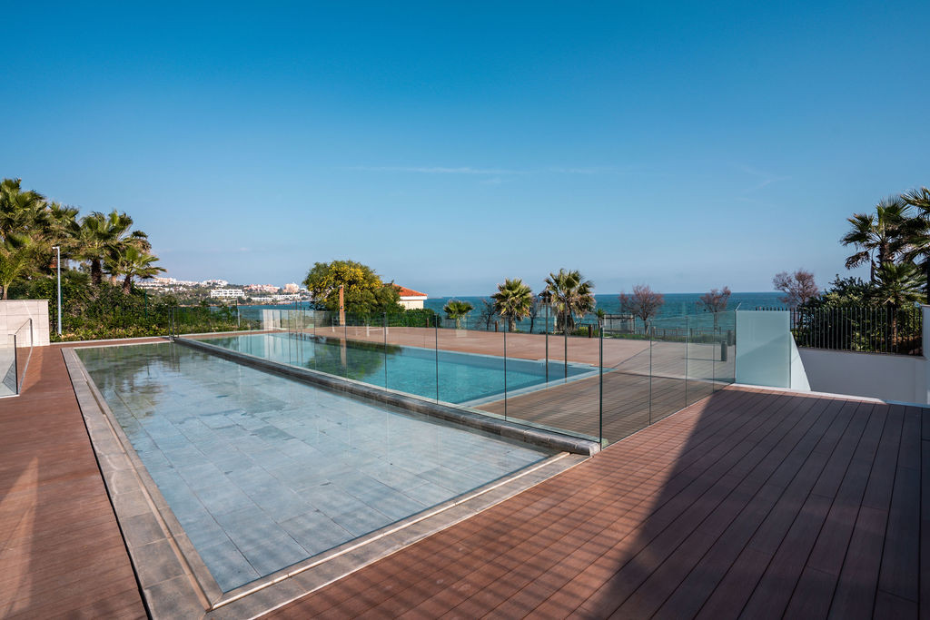 Outdoor pool area with a reflecting pool, swimming pool, and ocean views.