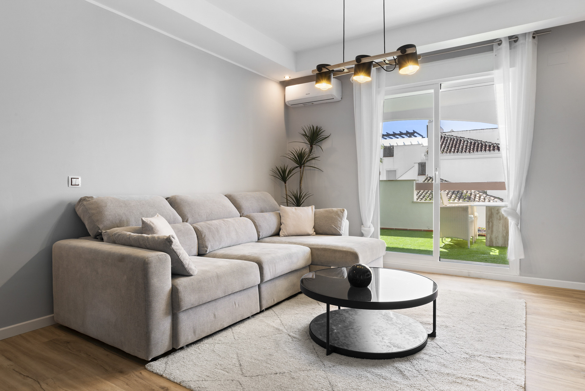 Cozy corner of the living room showing a sectional sofa and bright window access.