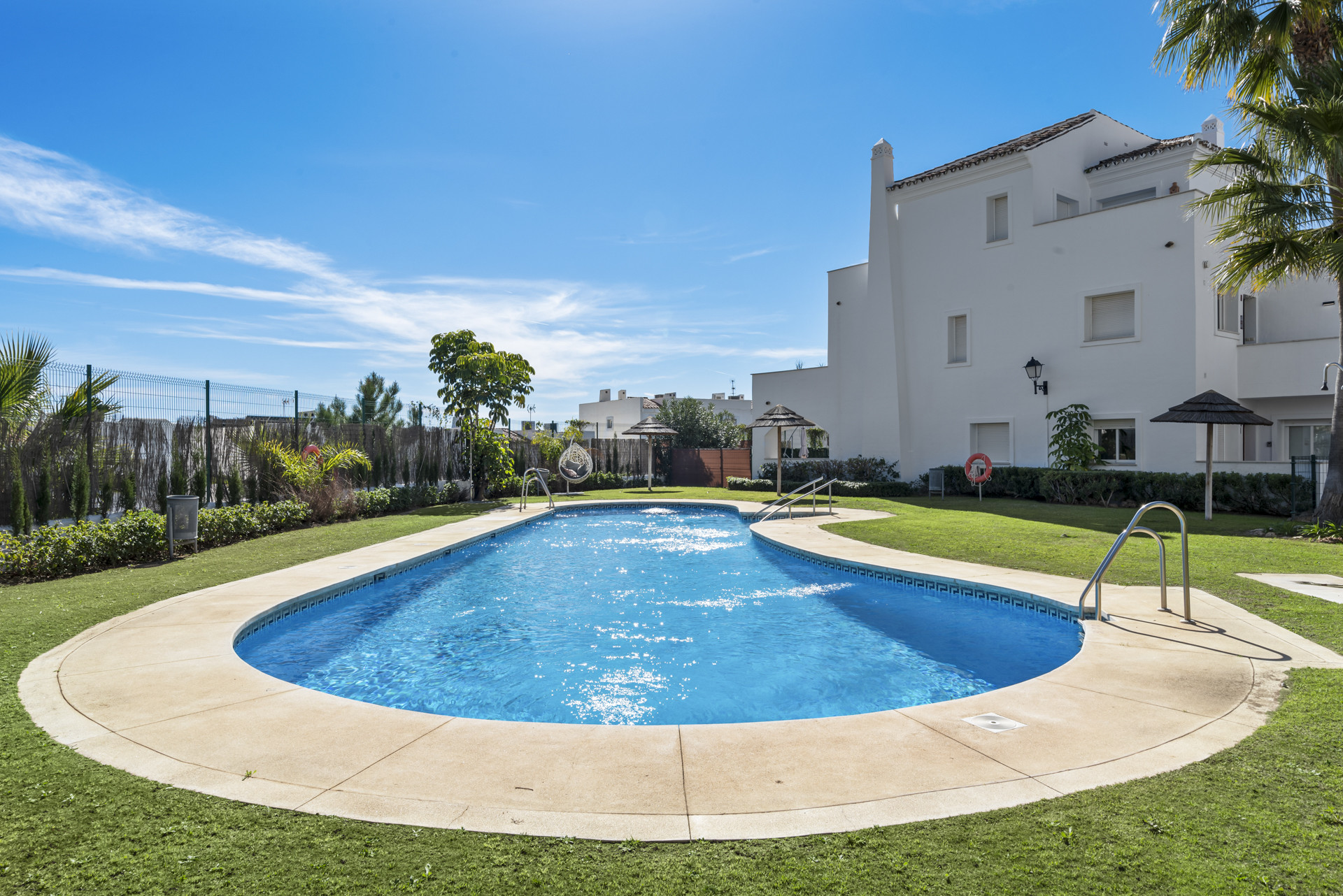 Another view of the pool, showing steps, sunbathing areas, and garden spaces.