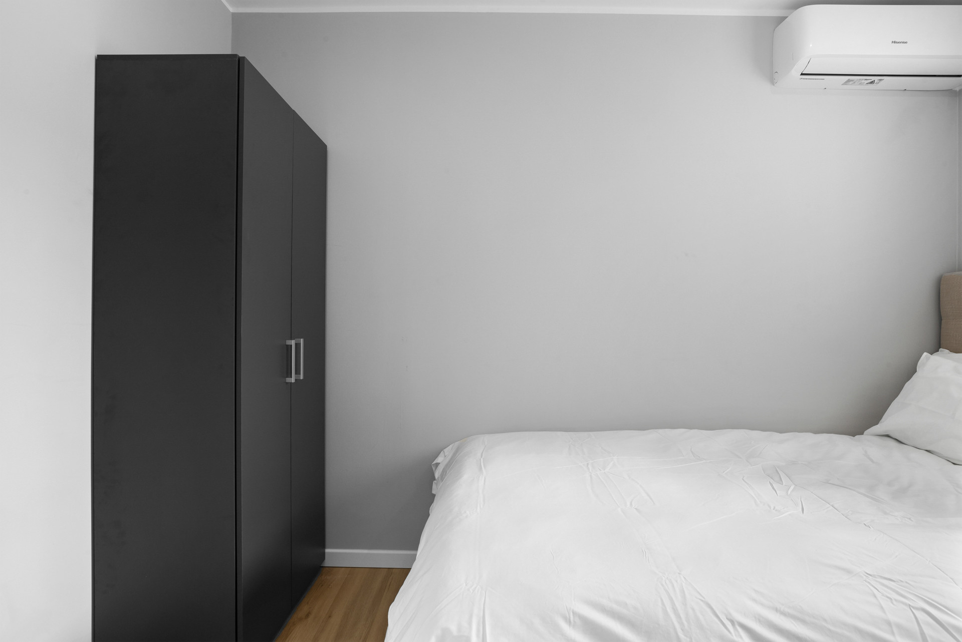Bedroom corner with a wardrobe beside the bed.