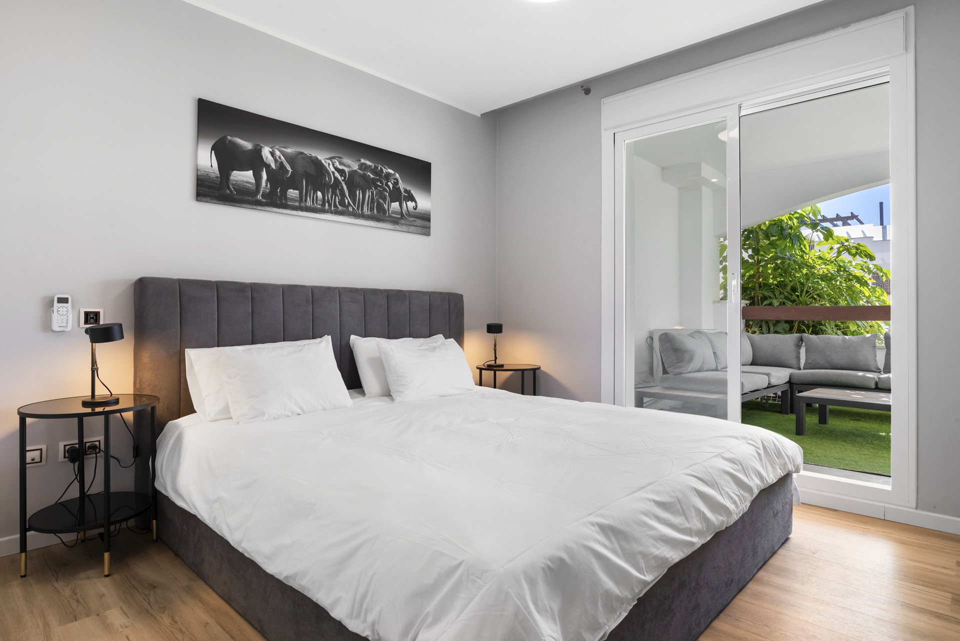 Cozy bedroom featuring a bed, side tables, and a patio view.