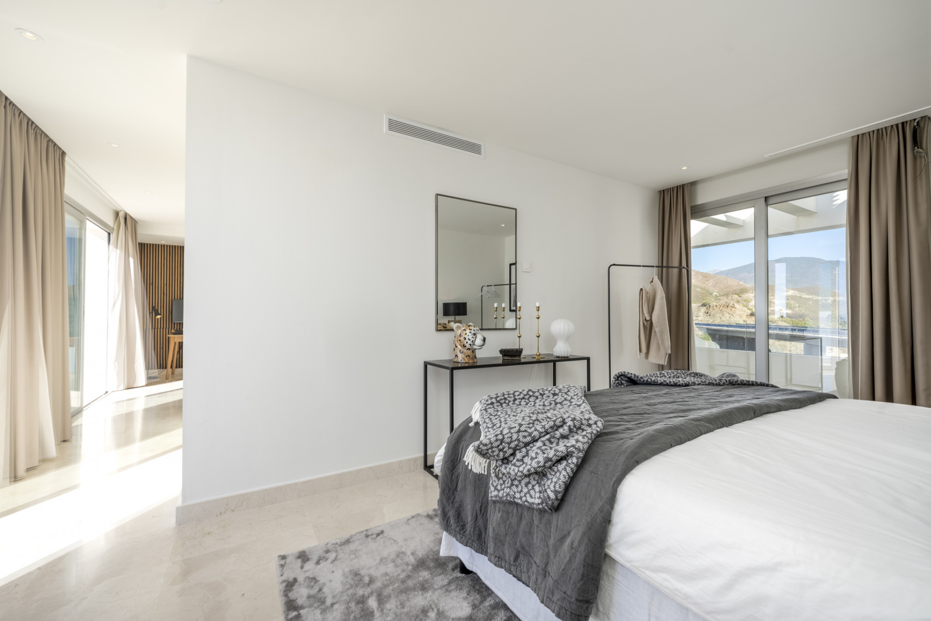 Corner of the master bedroom with a bed, decorative items, and access to a terrace.