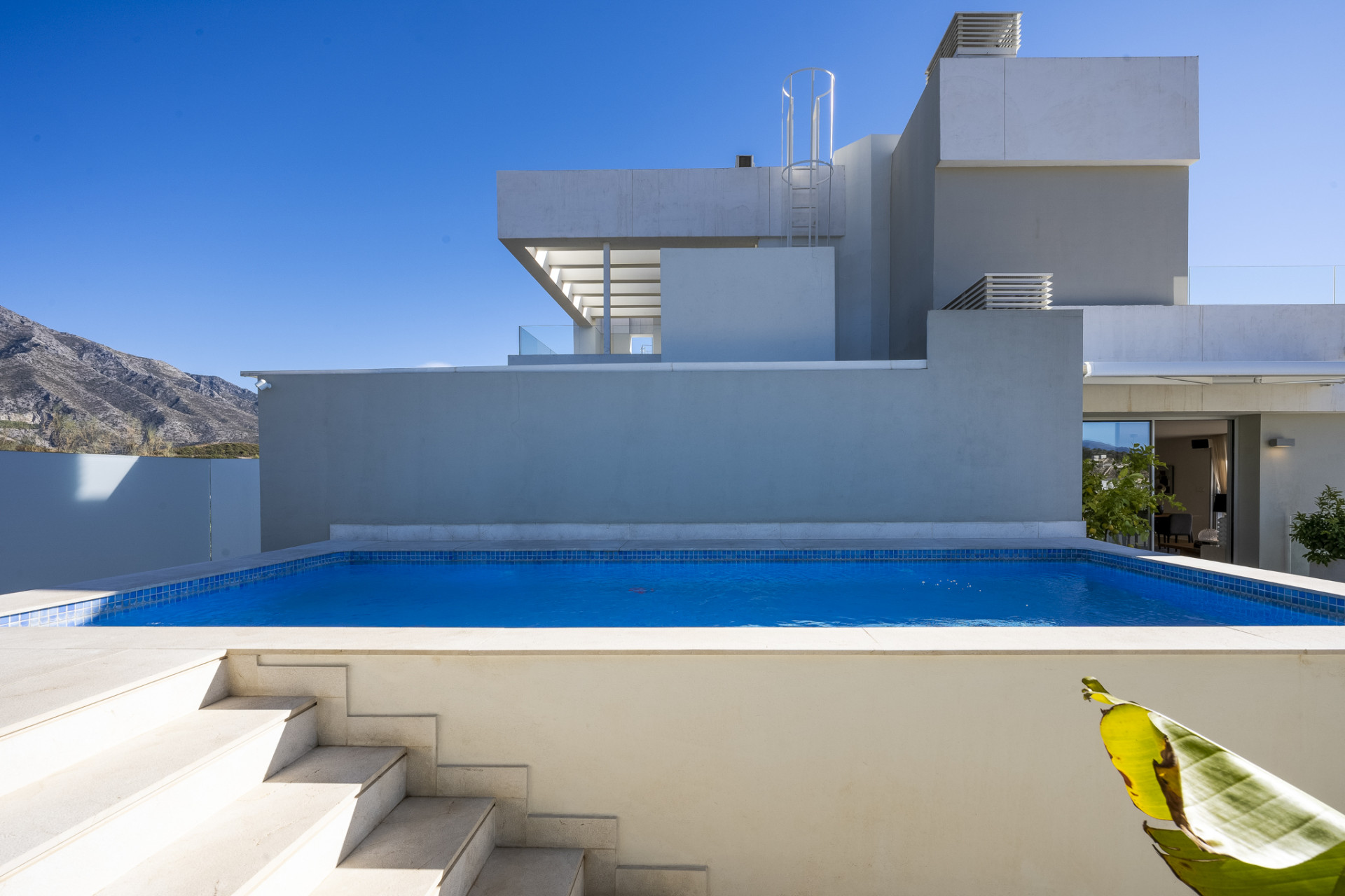 Private pool surrounded by architecture and greenery.