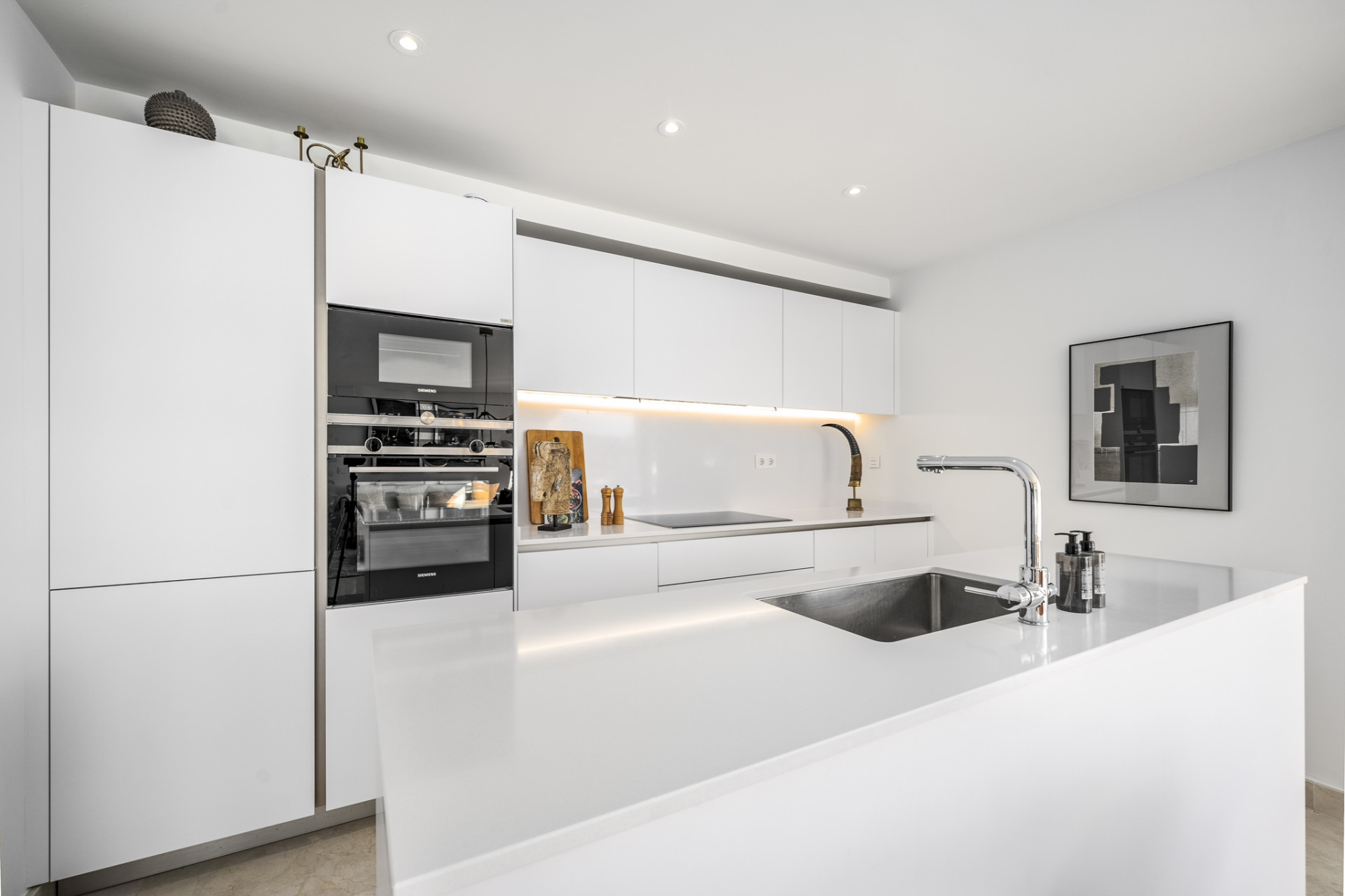 Modern kitchen with white cabinetry and built-in appliances