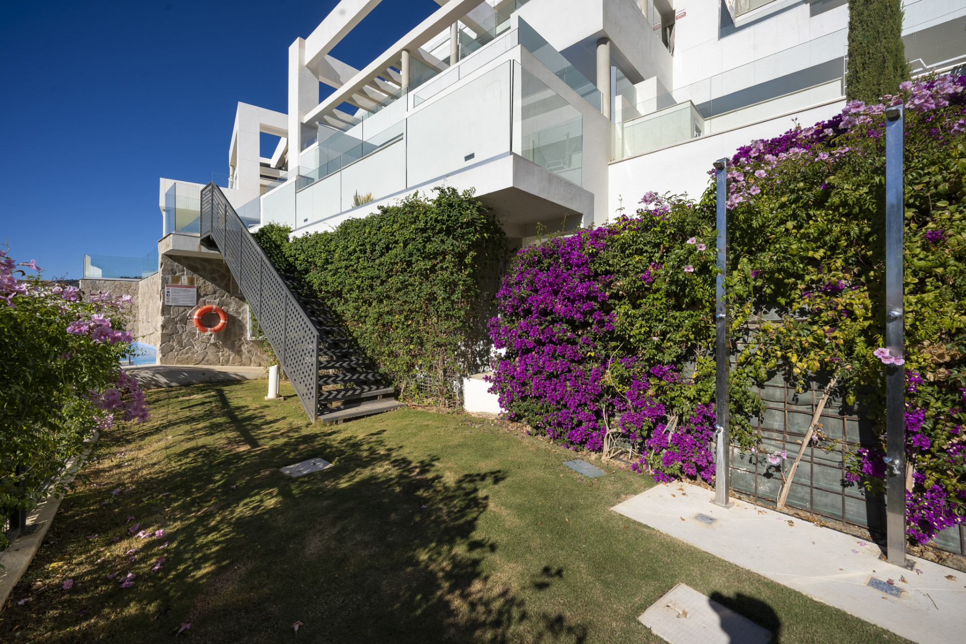 Staircase covered in bougainvillea leading to a spacious terrace area.