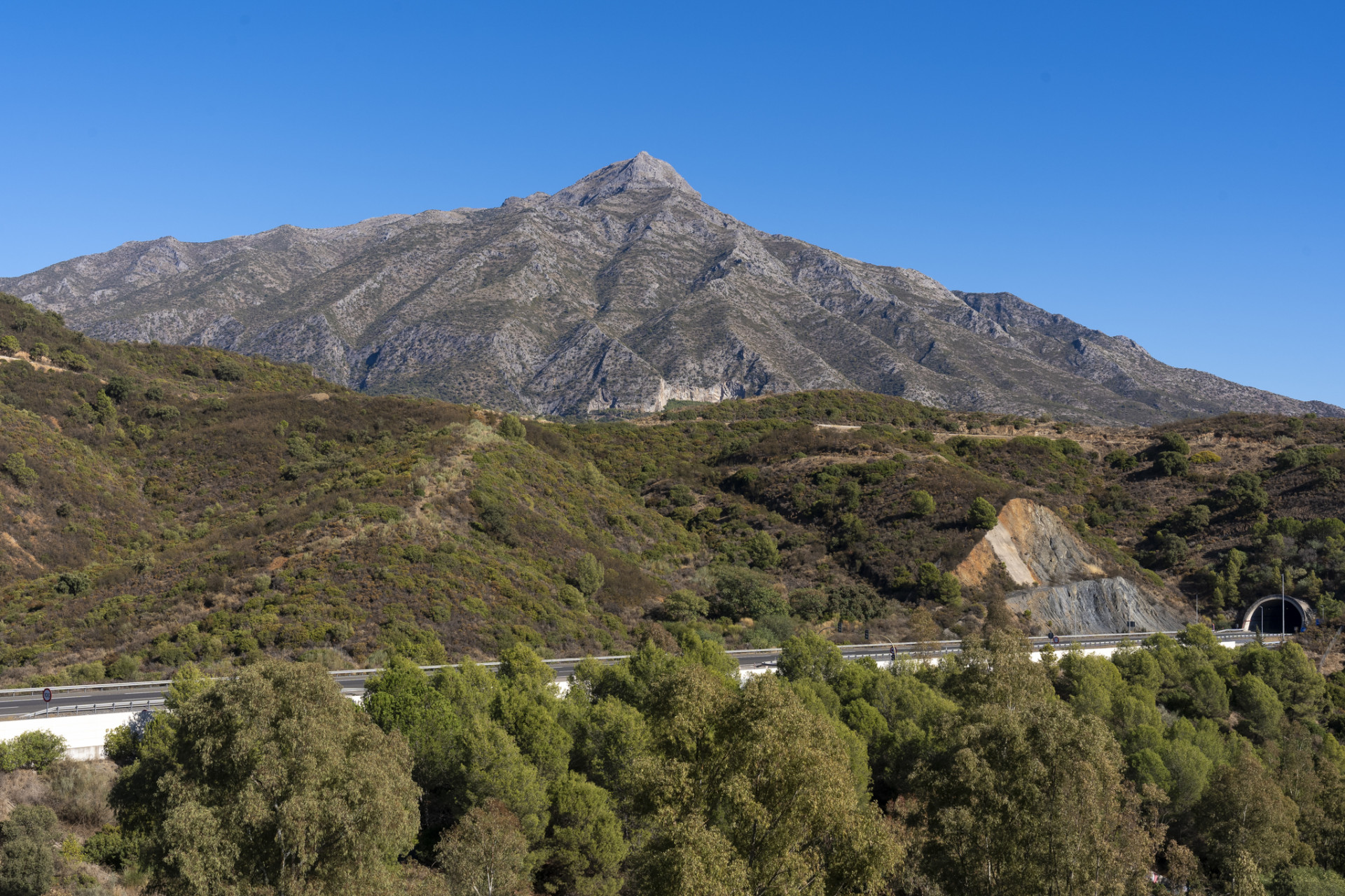 Mountain view showcasing rugged terrain and blue sky.