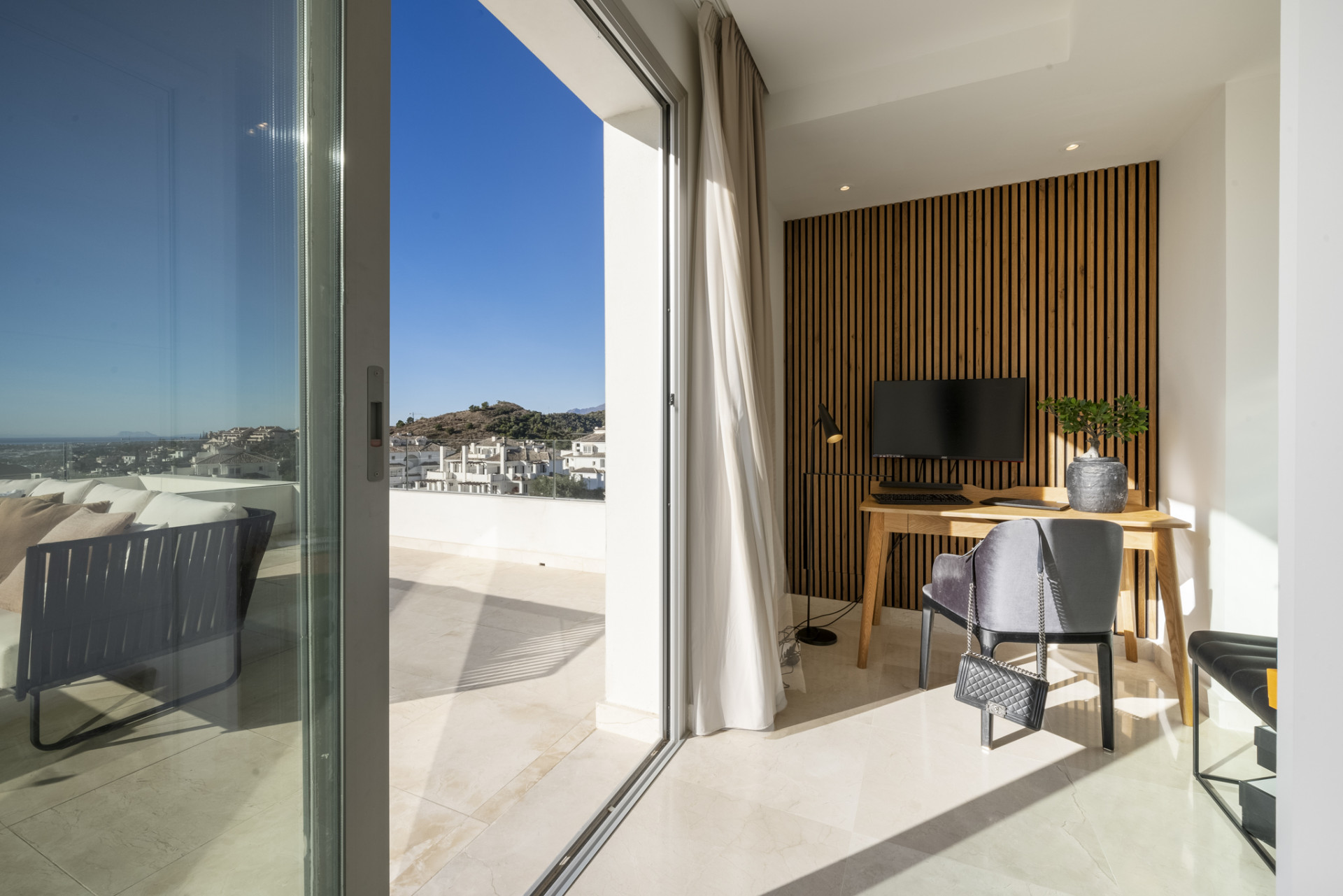 Home office area with a desk, chair, and view of the outdoor space.