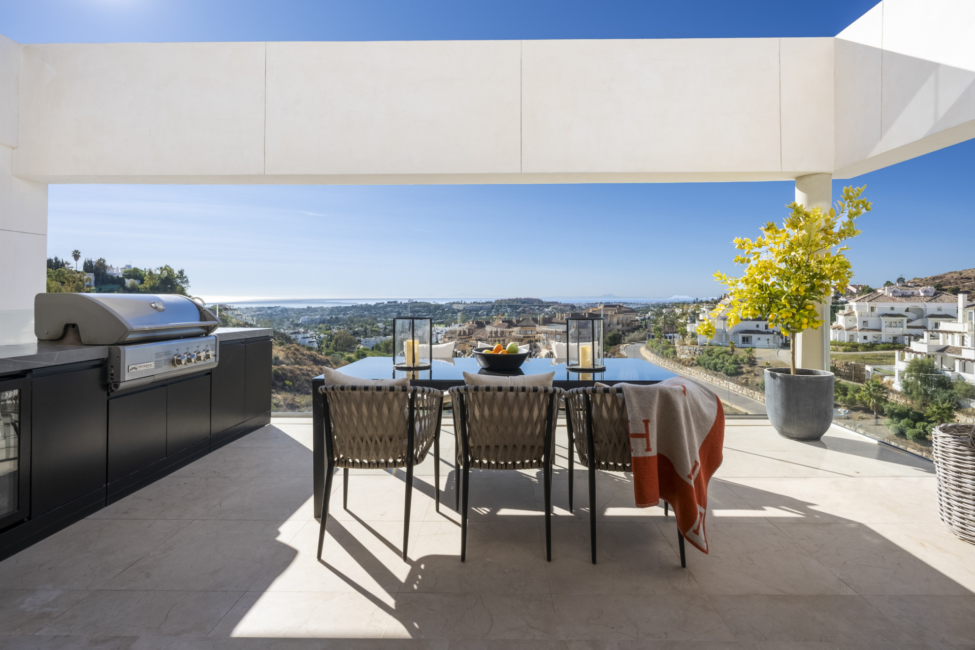 Outdoor dining area with a grill and panoramic views.