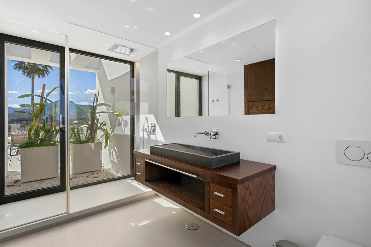 Bathroom with a floating wood vanity, black rectangular sink, large mirror, and glass doors to a patio.
