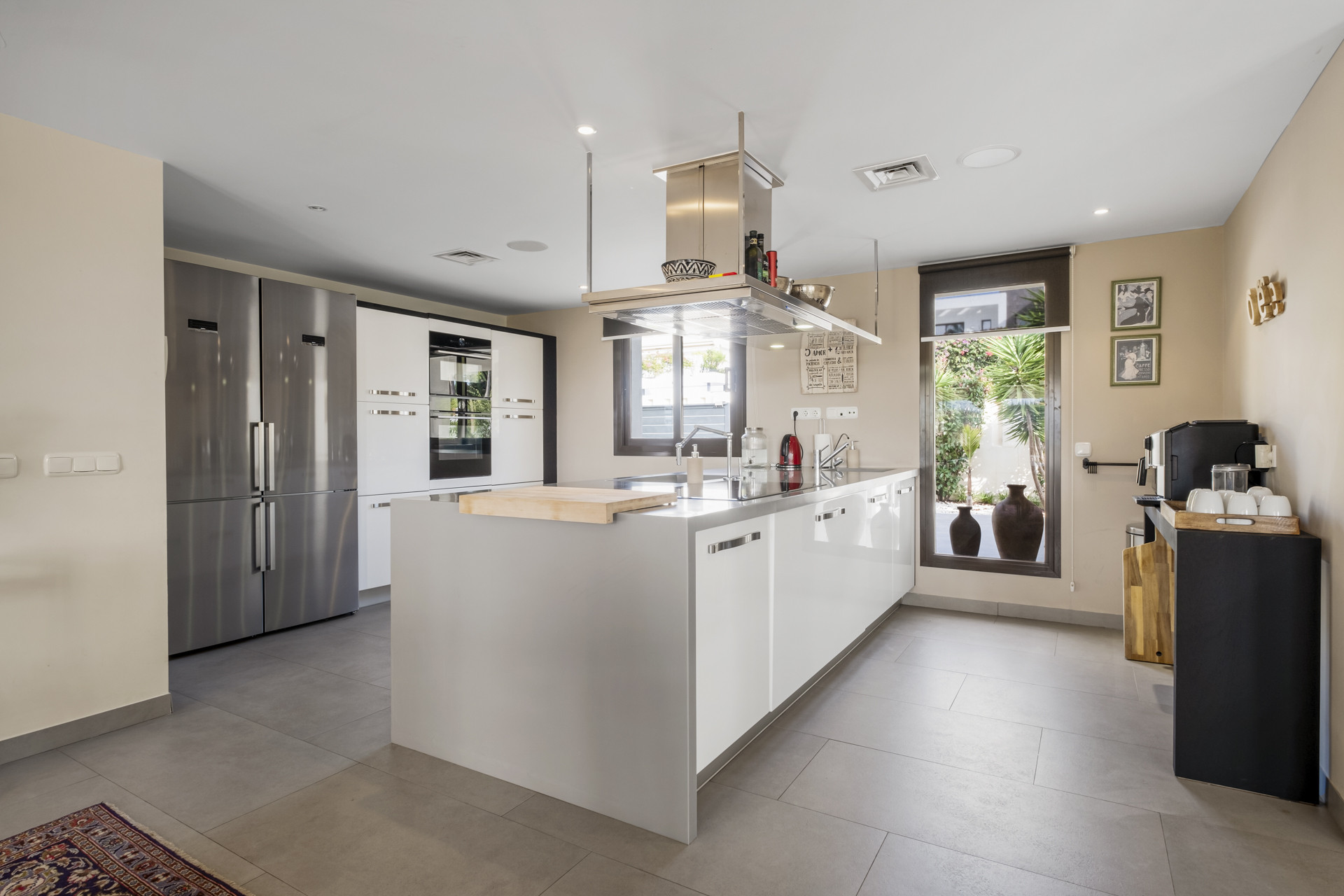 Modern kitchen with sleek cabinetry, large appliances, and a window overlooking the garden.