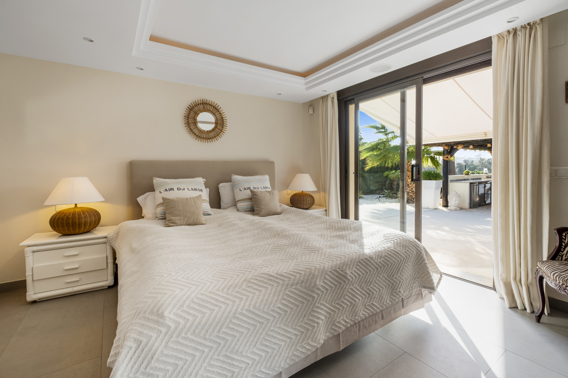 Second bedroom with a large bed, decorative items, and terrace access.