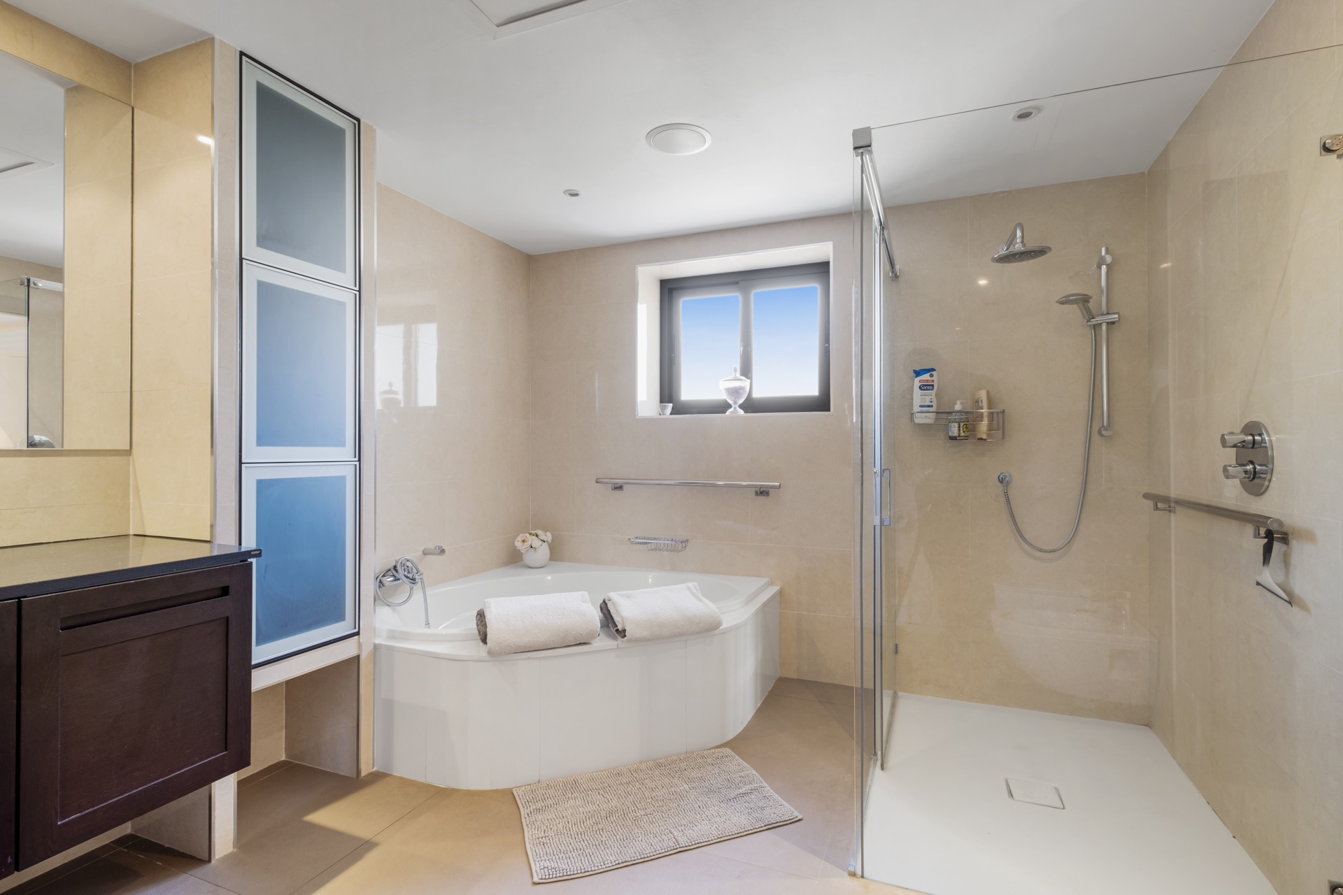 Modern bathroom with a separate shower and tub, elegantly tiled with natural light coming in.