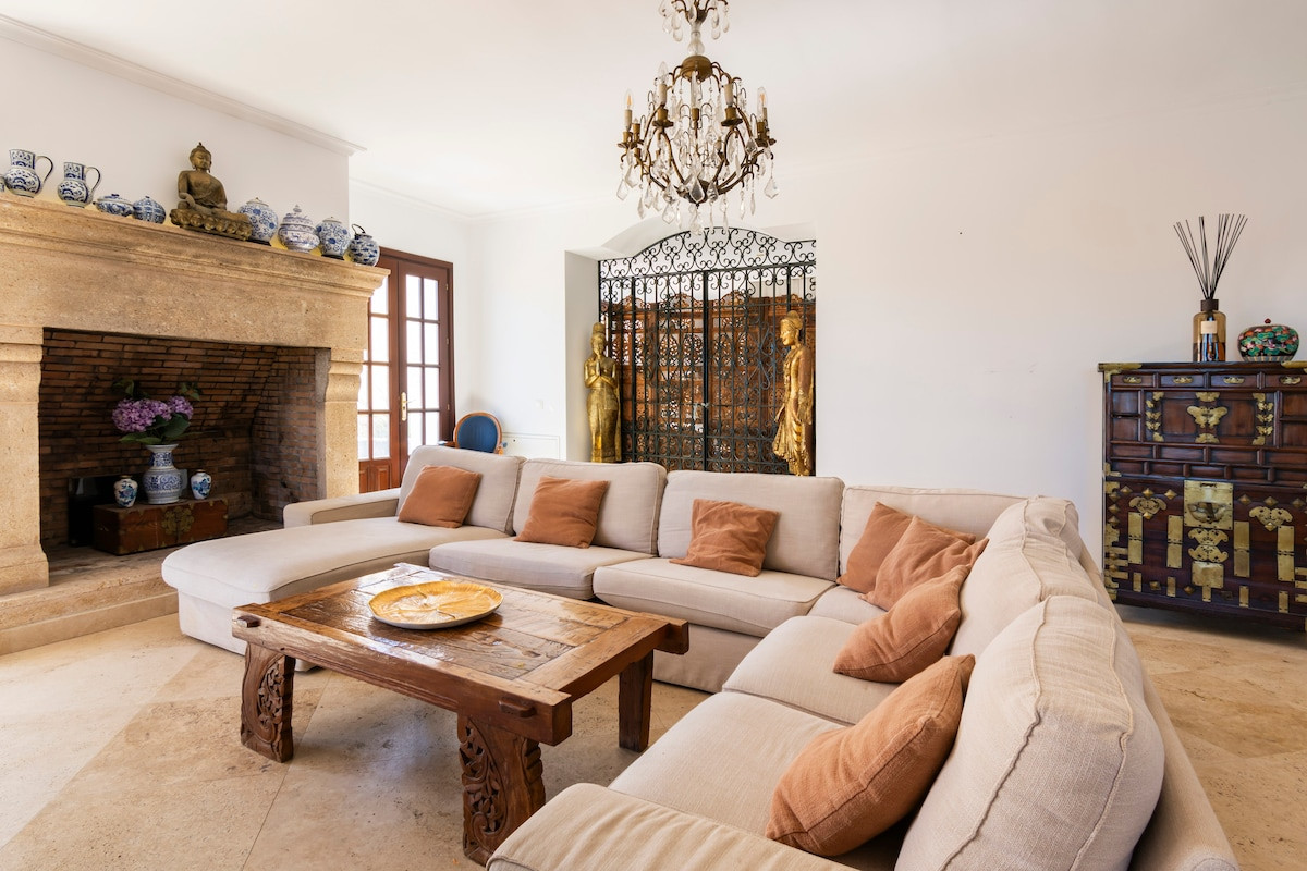 Cozy living room featuring a sectional sofa and an ornate fireplace.
