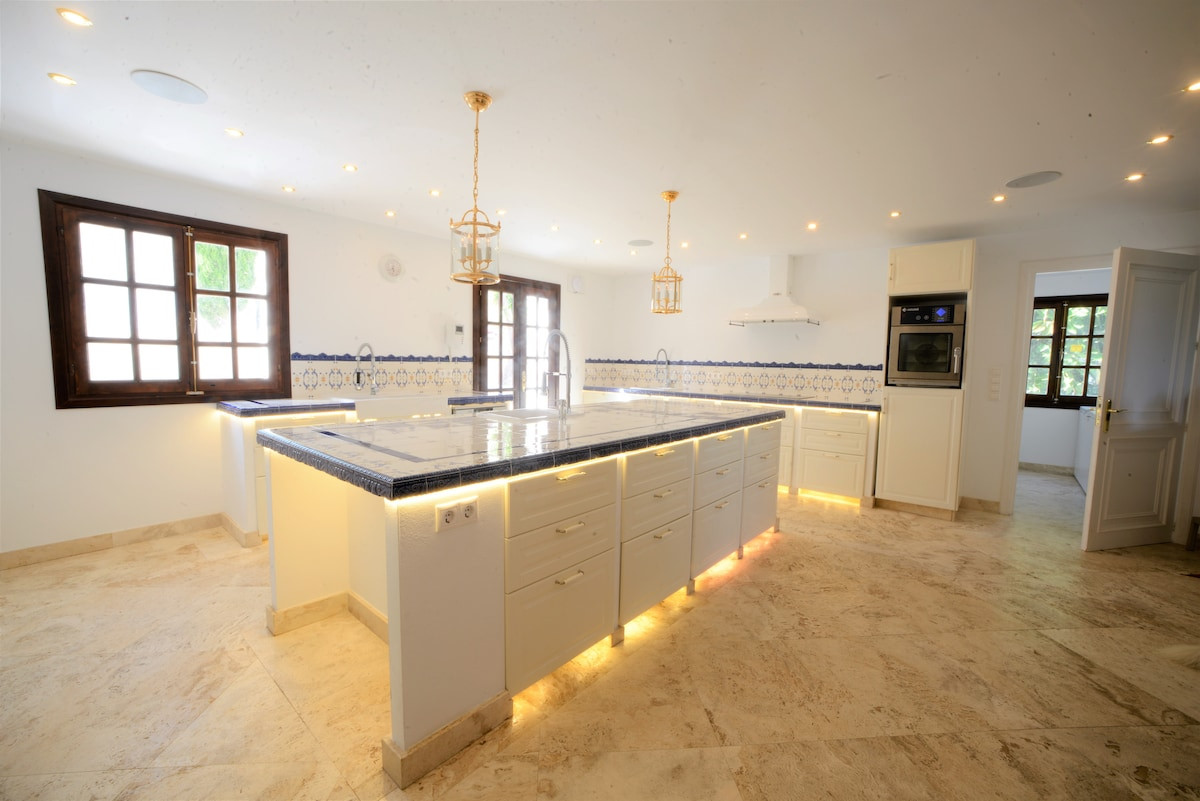 Light-filled kitchen with decorative tiles and dual windows.