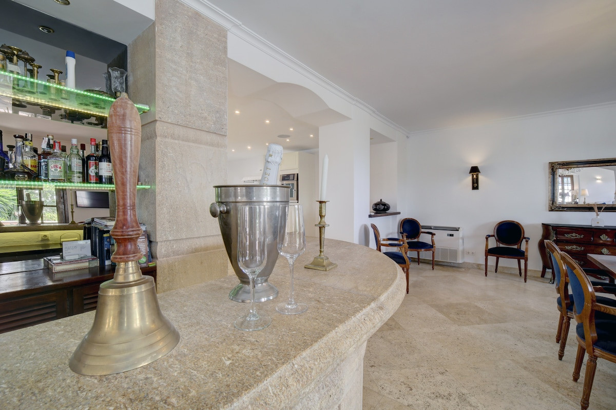 A close-up of a bar area with a bell, glasses, and a metallic ice bucket.
