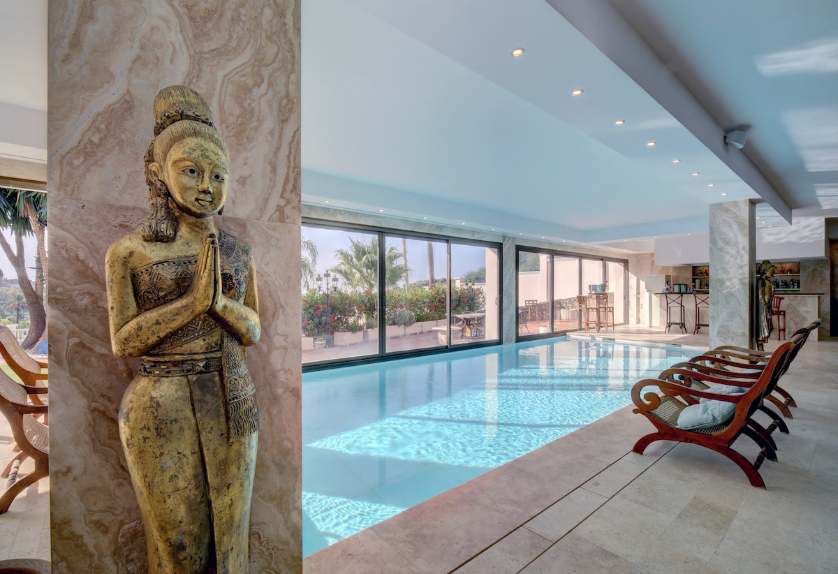 Indoor swimming pool area with a golden statue and large glass windows.