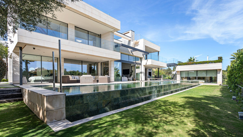Exterior view of the house showcasing a pool and garden area.