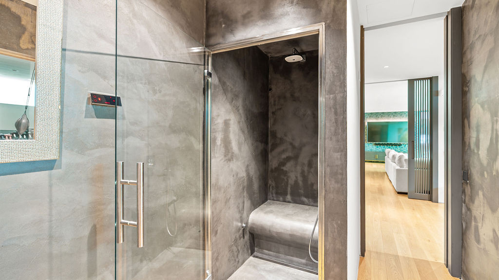 Sleek shower area with lined walls and glass door detail.