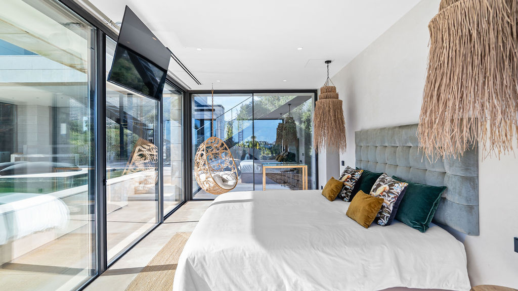 Cozy bedroom featuring a hanging chair and modern decor.