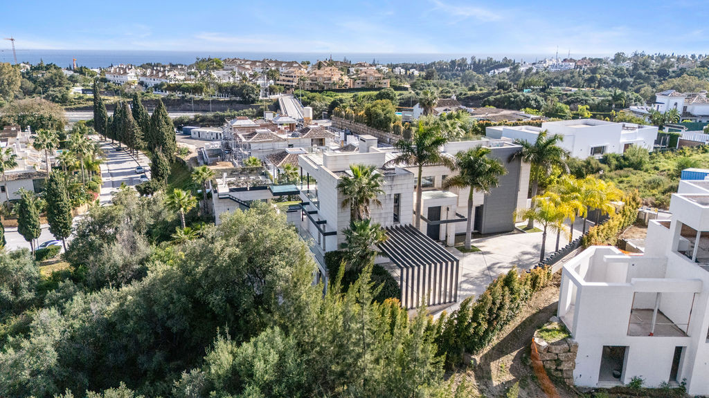 Showing the house and surrounding landscape with ocean view in the distance.