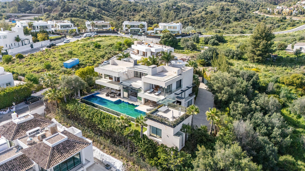 Aerial view of a modern house with a pool and landscaped gardens in Marbella.