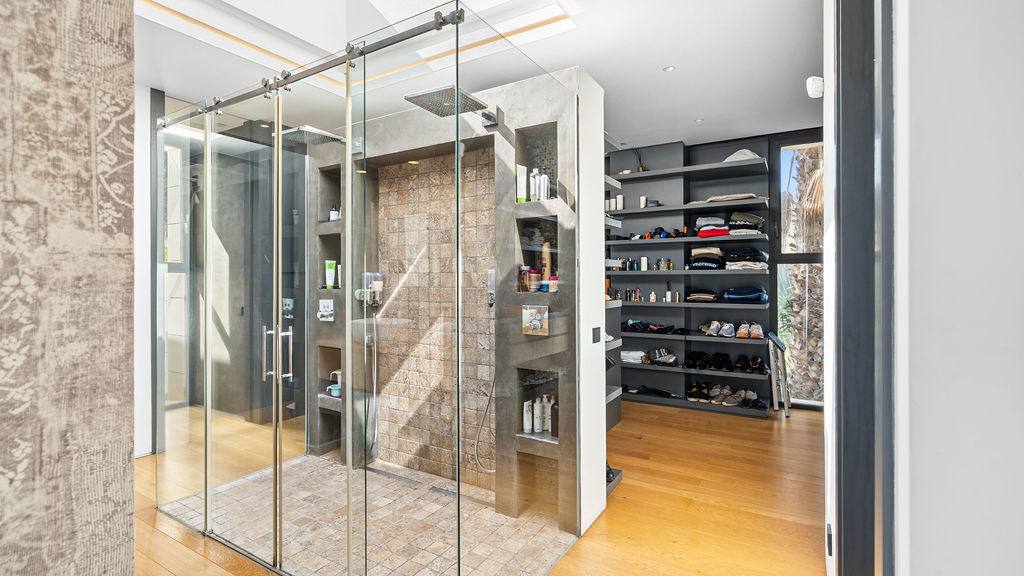 Shower area with glass enclosure and storage space.