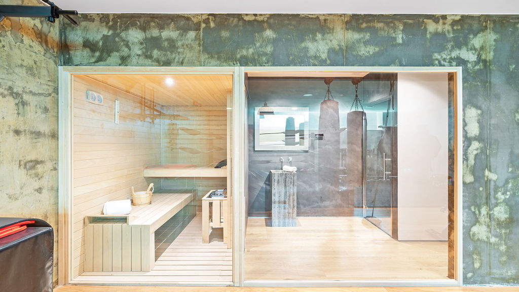 Sauna area on the left with wooden interior, adjacent to a glass-enclosed shower room.