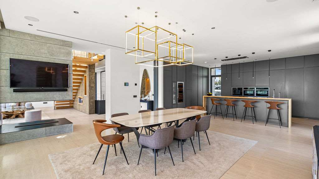 Dining view showcasing an elegant table, sleek cabinetry, and contemporary lighting, with open space concept.