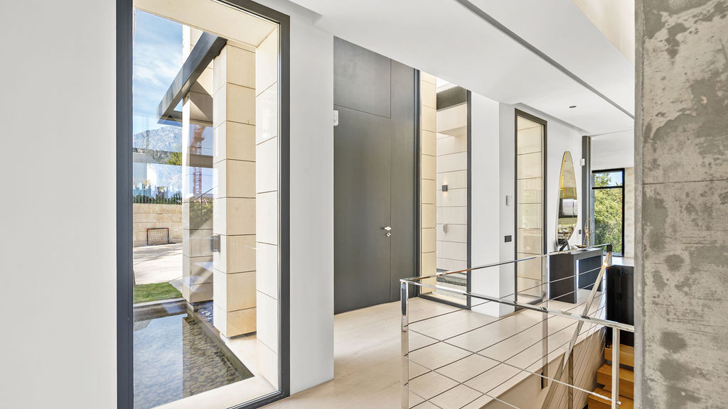 Entrance hallway with glass walls and a view of the outdoor garden.