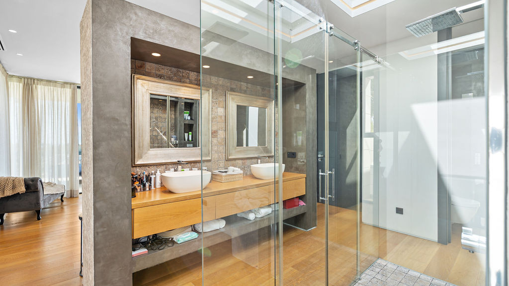 Stylish bathroom with double sinks and glass shower.