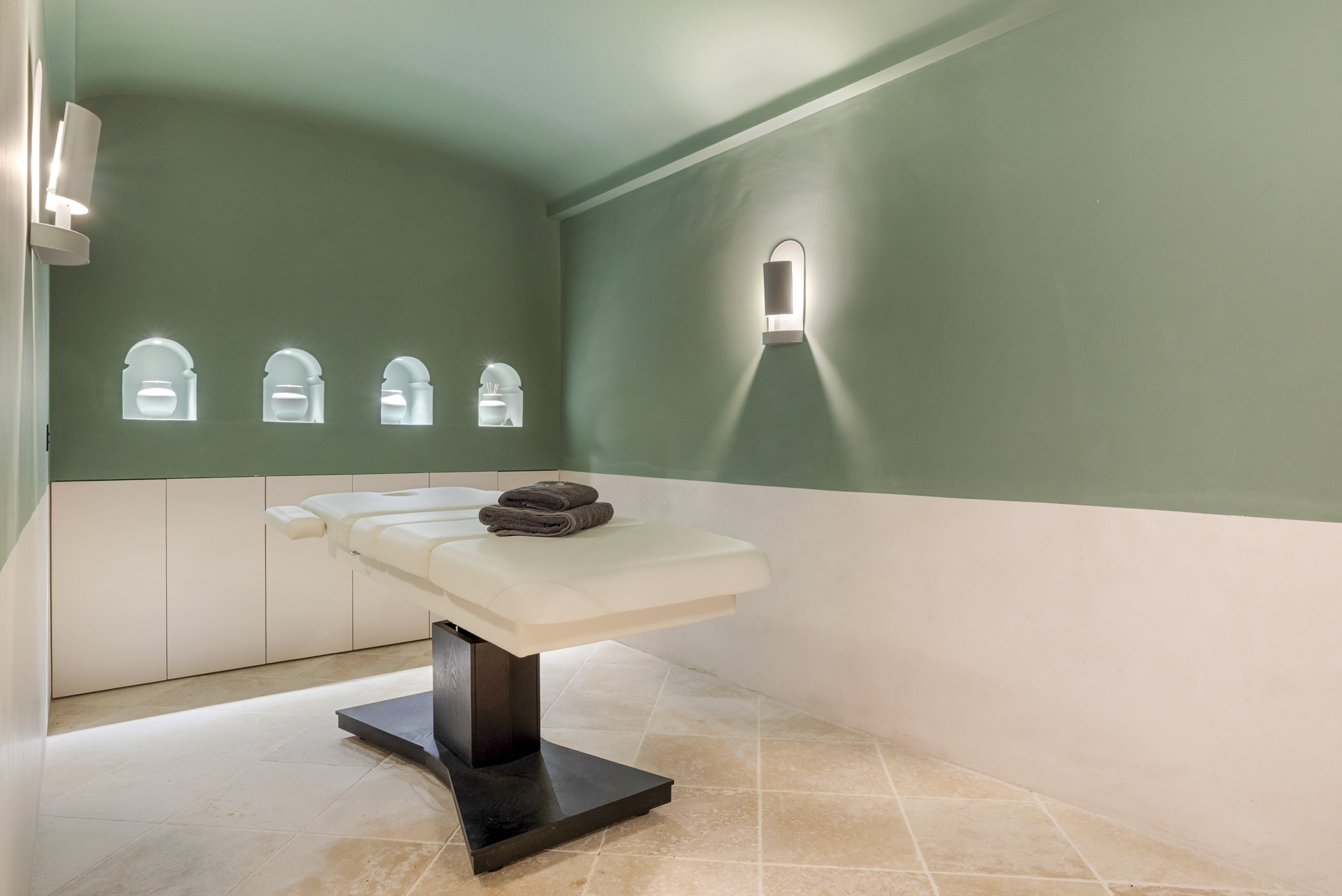 Tranquil massage room with a treatment table and softly lit walls.