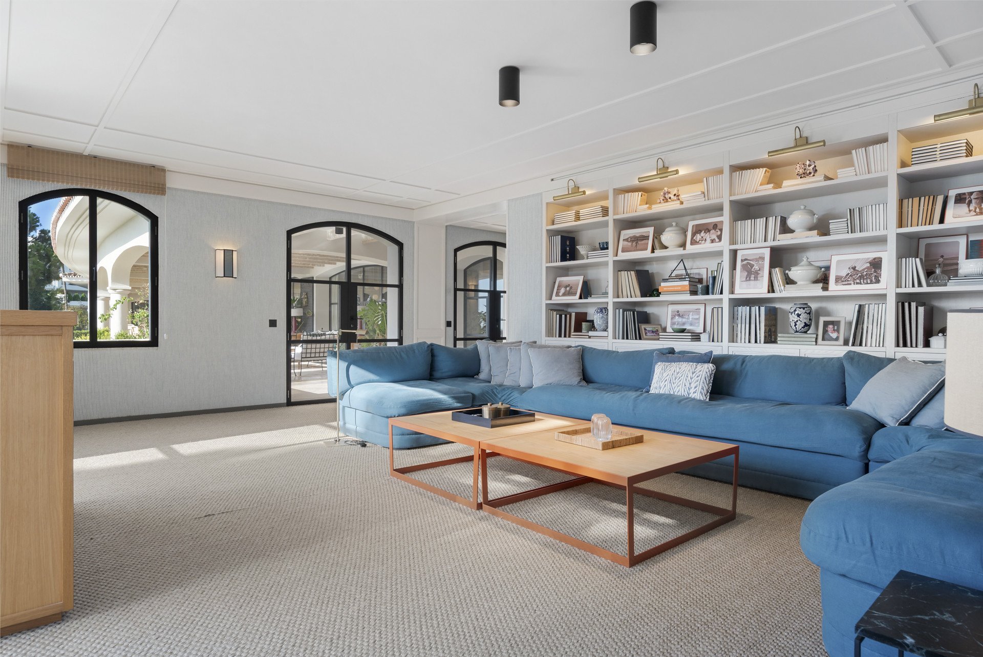 Inviting living room featuring a blue sectional sofa, coffee table, and built-in bookshelves with decor.