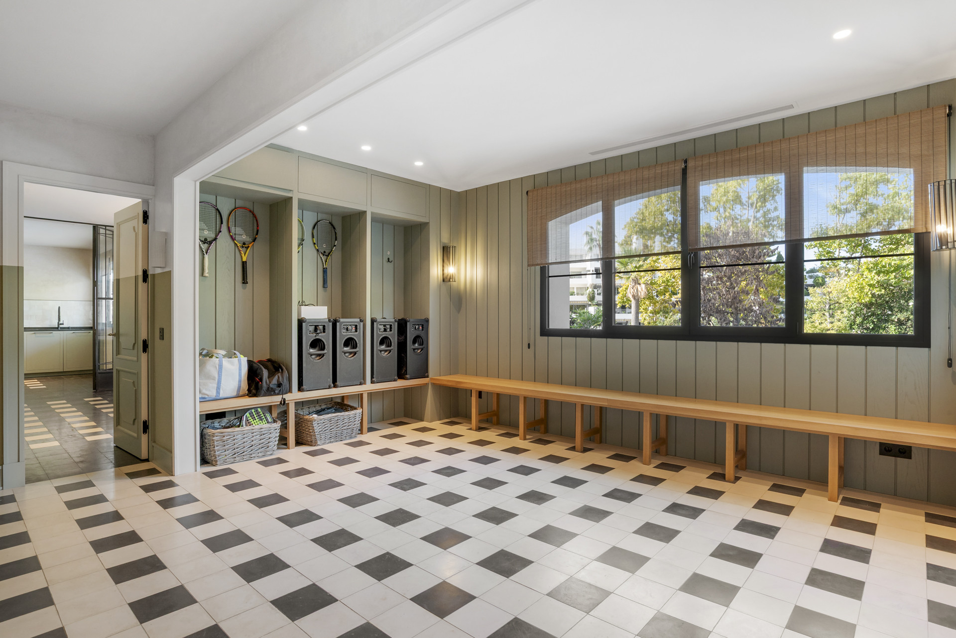 Mudroom with benches and storage for sports equipment and laundry.