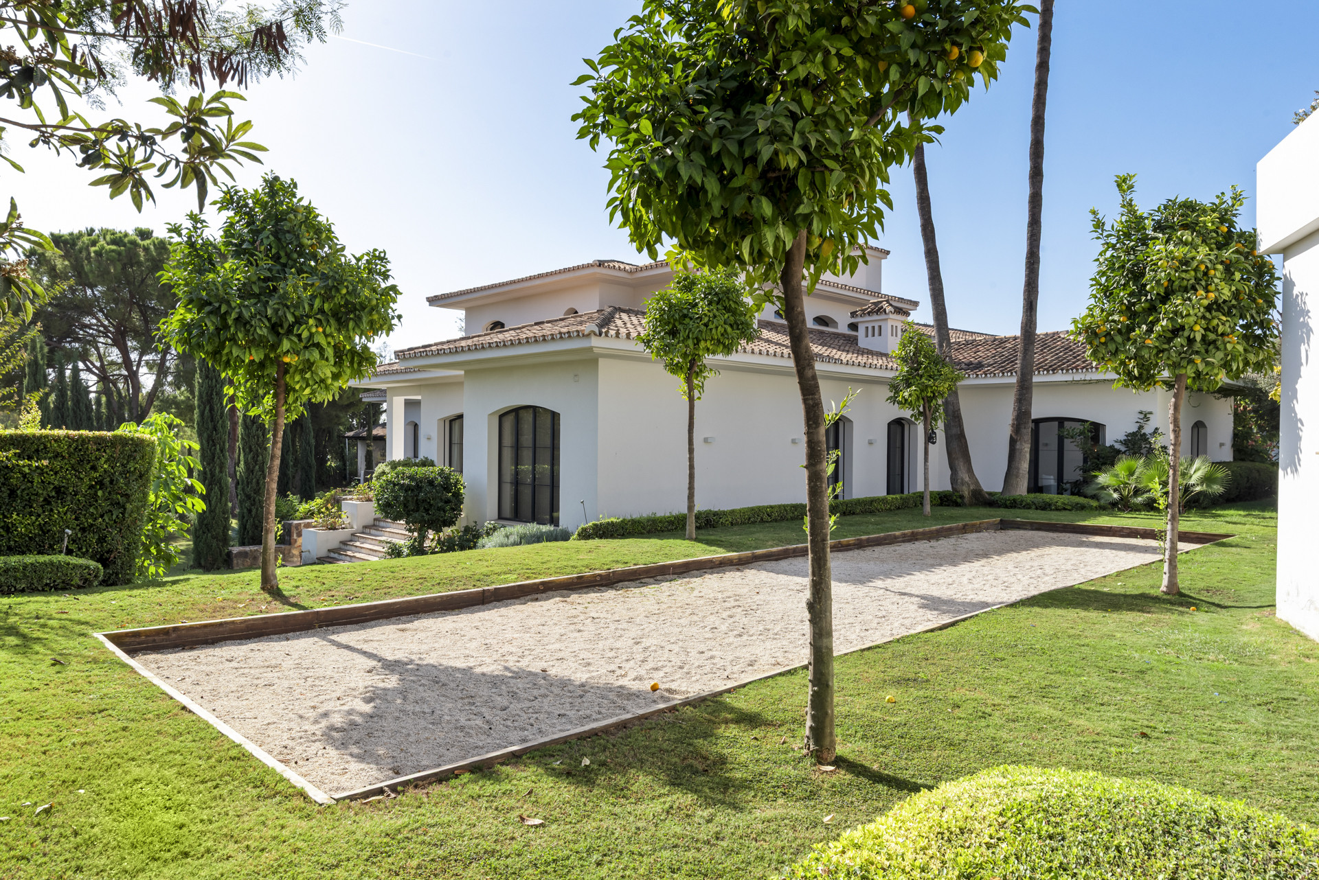 Exterior view of the house with manicured lawns and trees in Marbella.