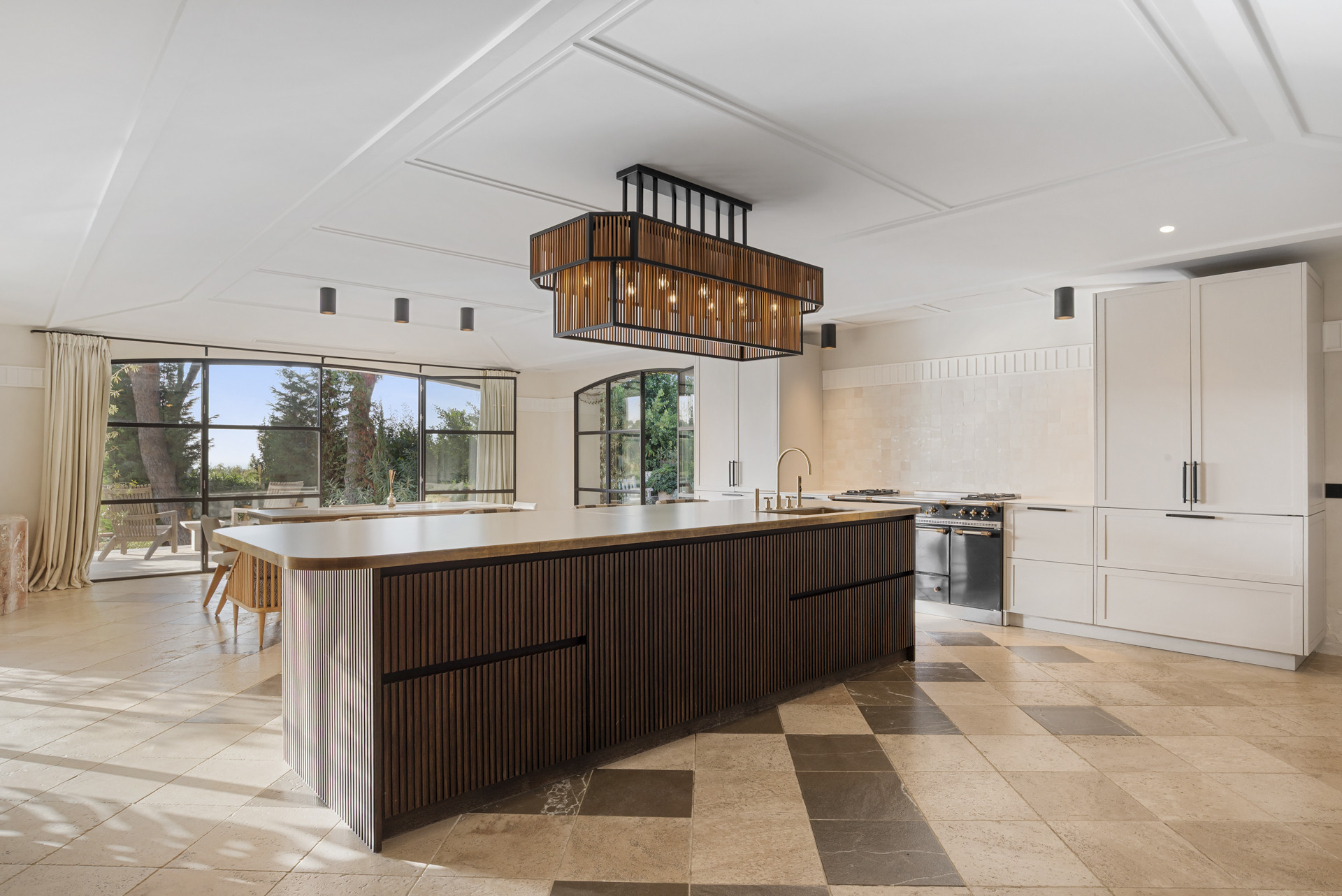 Modern kitchen with a large island and stylish pendant light above.