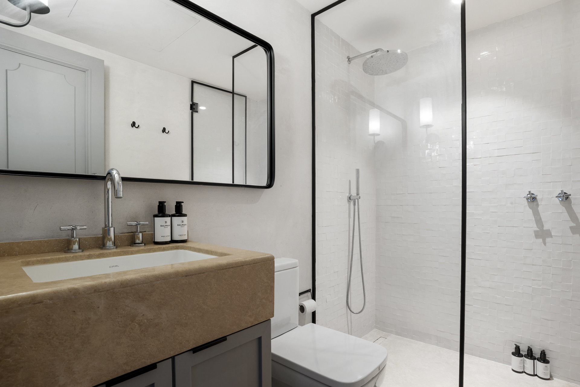 Modern bathroom with a spacious glass shower, elegant sink, and stylish mirror.