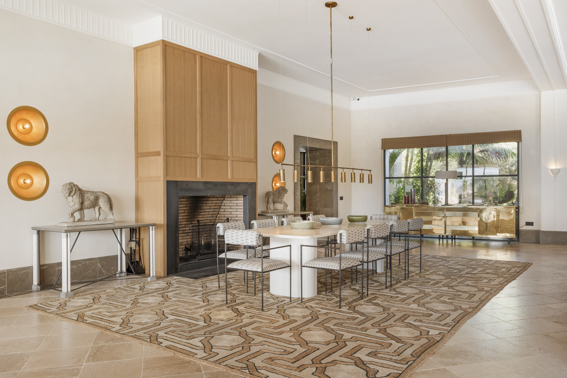 Spacious dining area with a circular table, stone lion sculpture, and modern lighting fixtures.