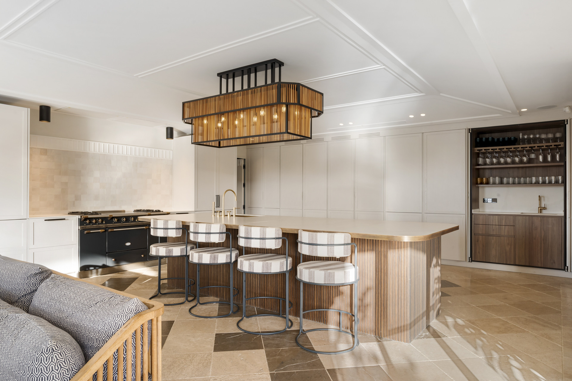 Spacious kitchen with an island bar, modern appliances and decorative lighting.
