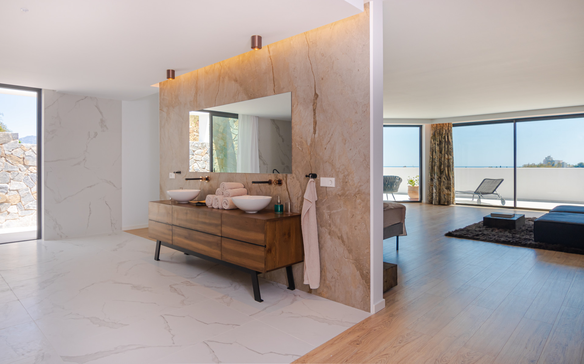 Spacious bathroom with dual sinks, natural light through large windows, and elegant decor.
