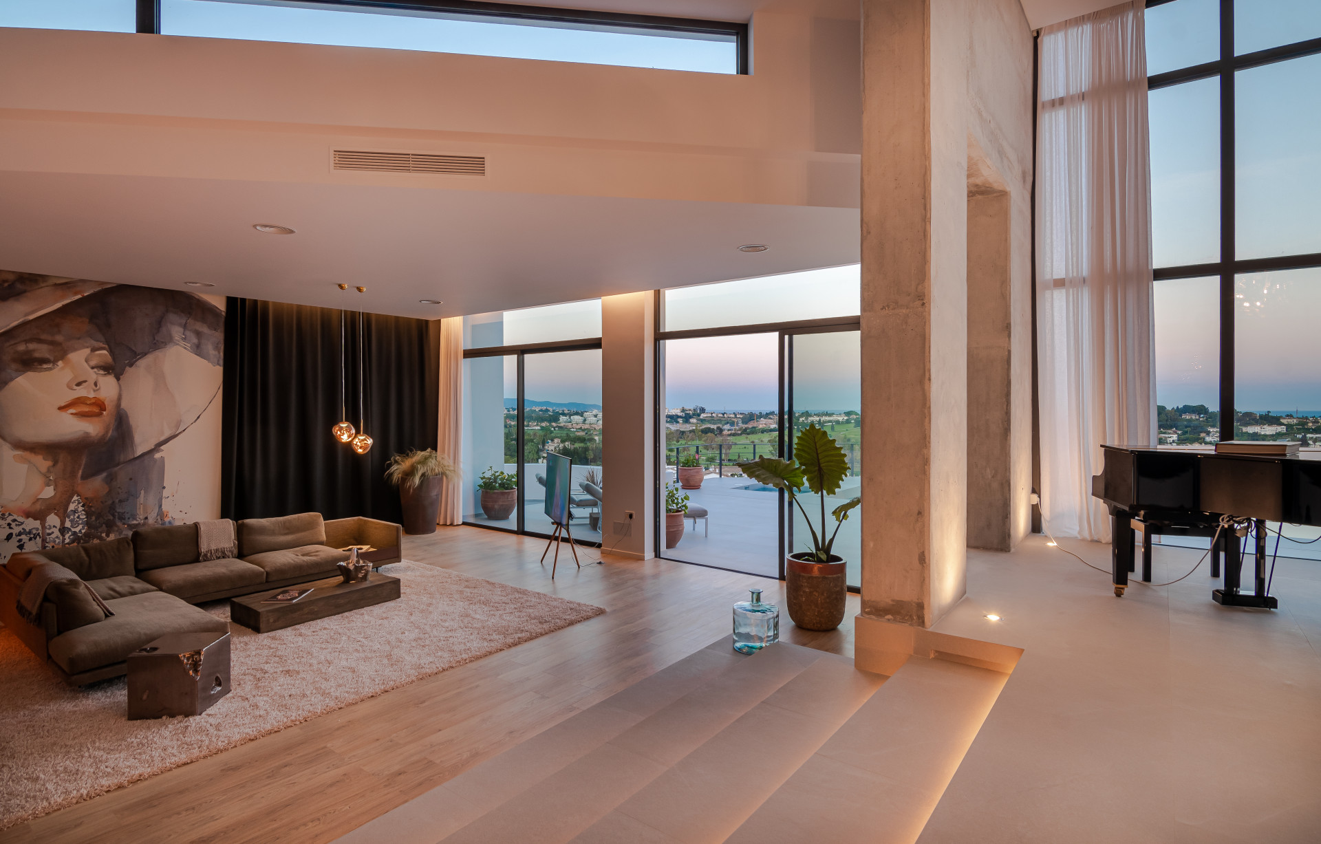 Cozy corner with a large sofa and a decorative wall, opening to a terrace view.