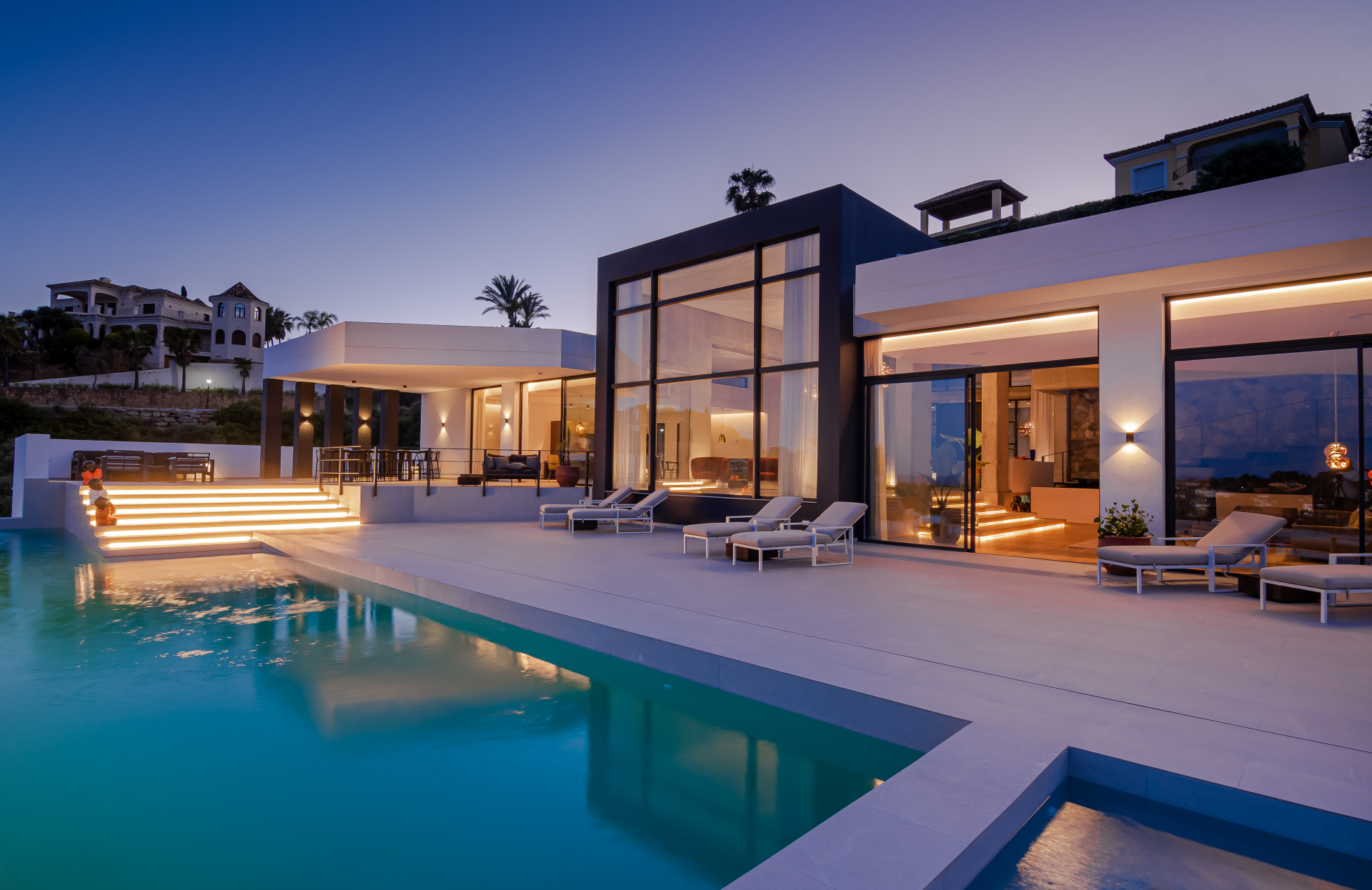 Viewing angle of the house featuring a lit staircase and pool.