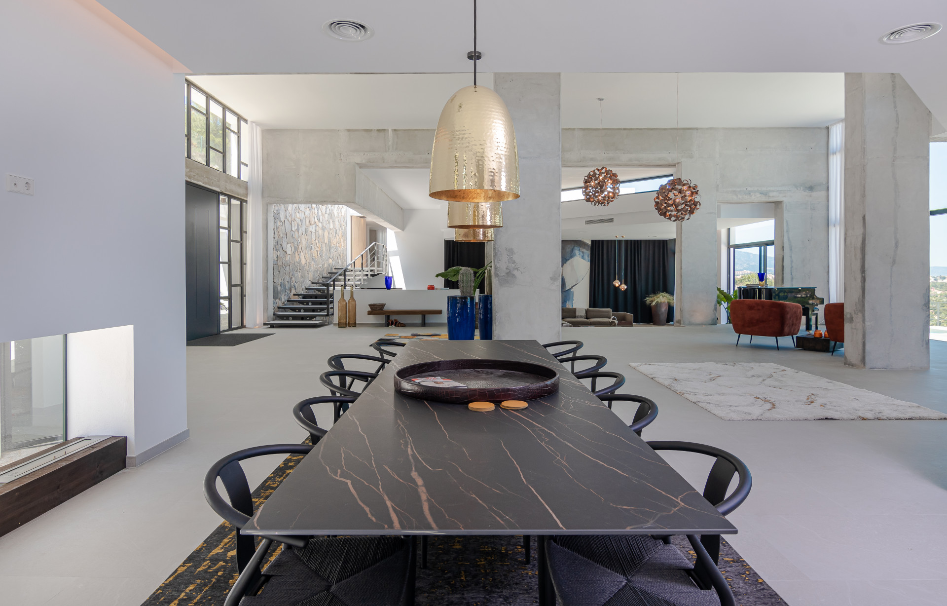 Modern dining area featuring a long table and prominent lighting fixtures