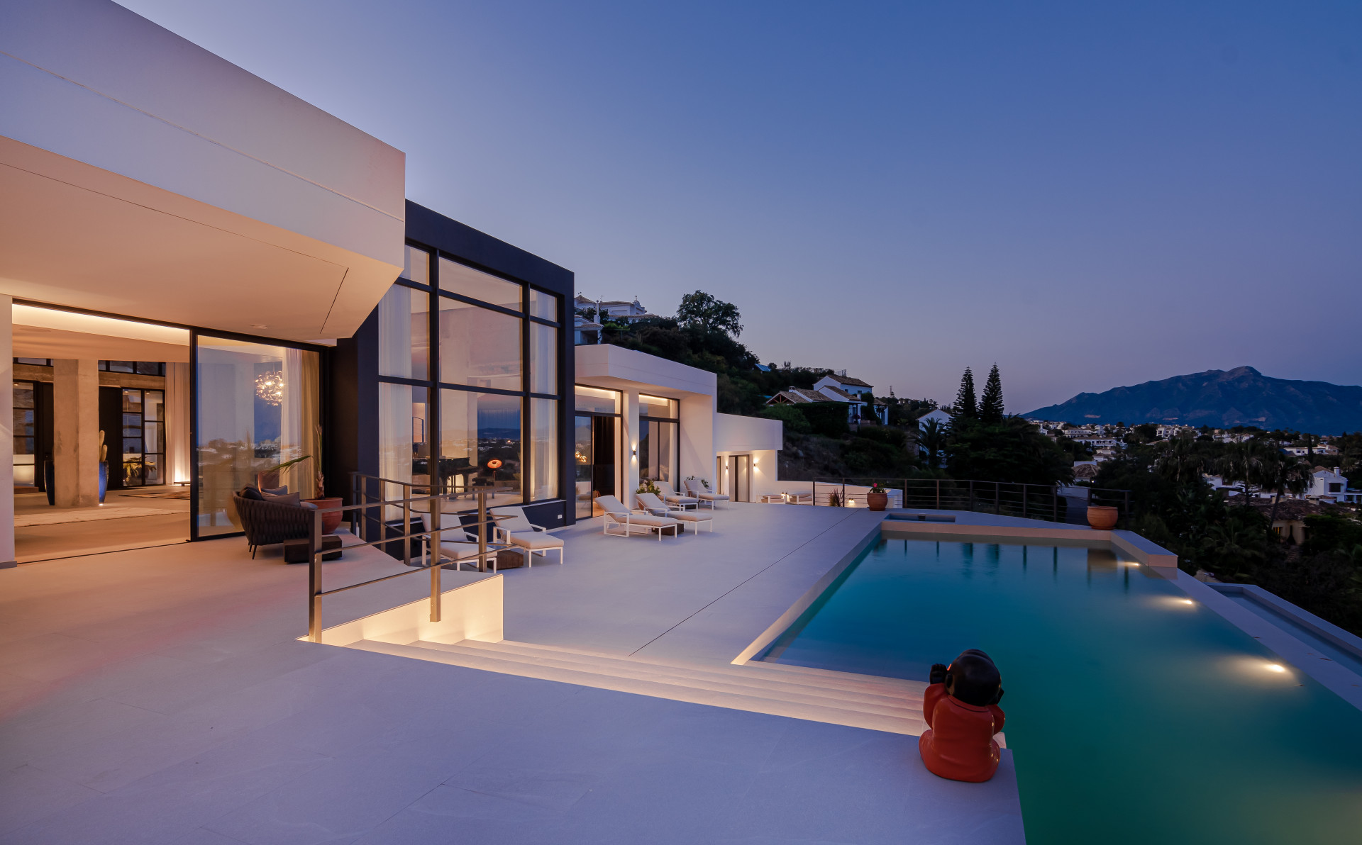 Exterior view of the house with night lighting and pool area.