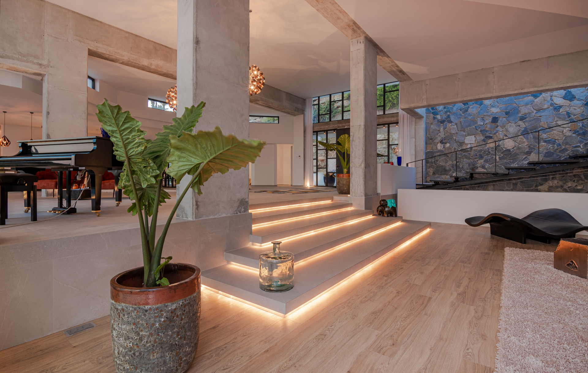 Well-lit staircase with LED accents leading to a dual-level living area.