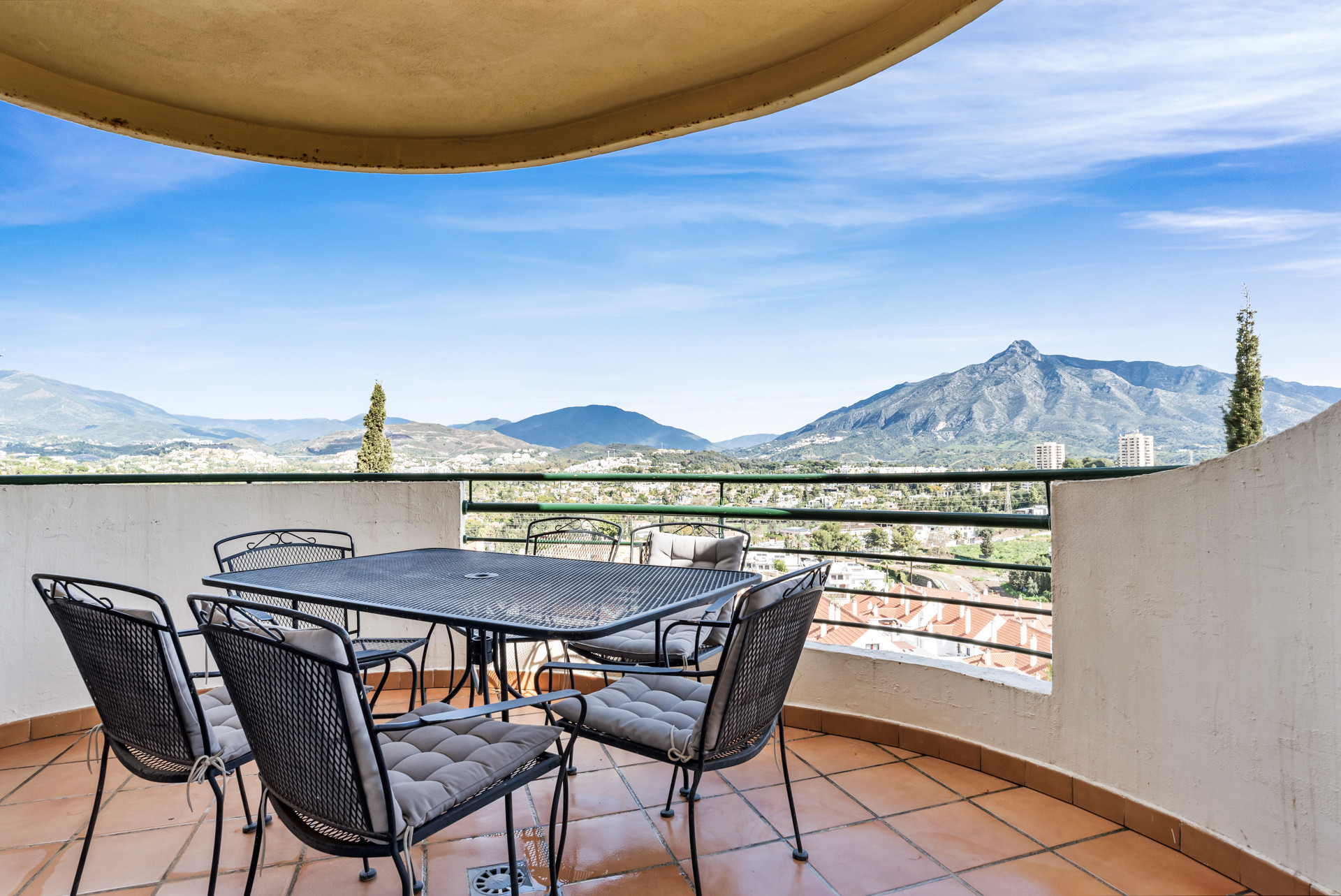 Spacious terrace with a dining table and mountain views in the background.
