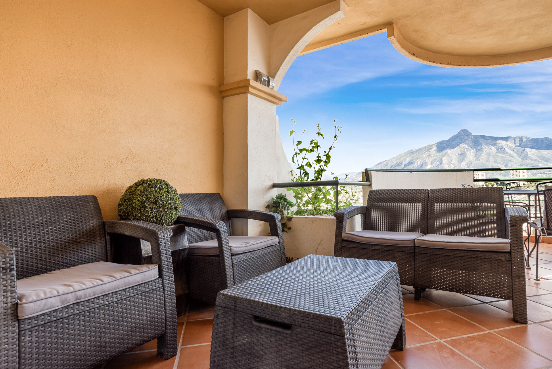 Balcony area with outdoor seating and mountain view.