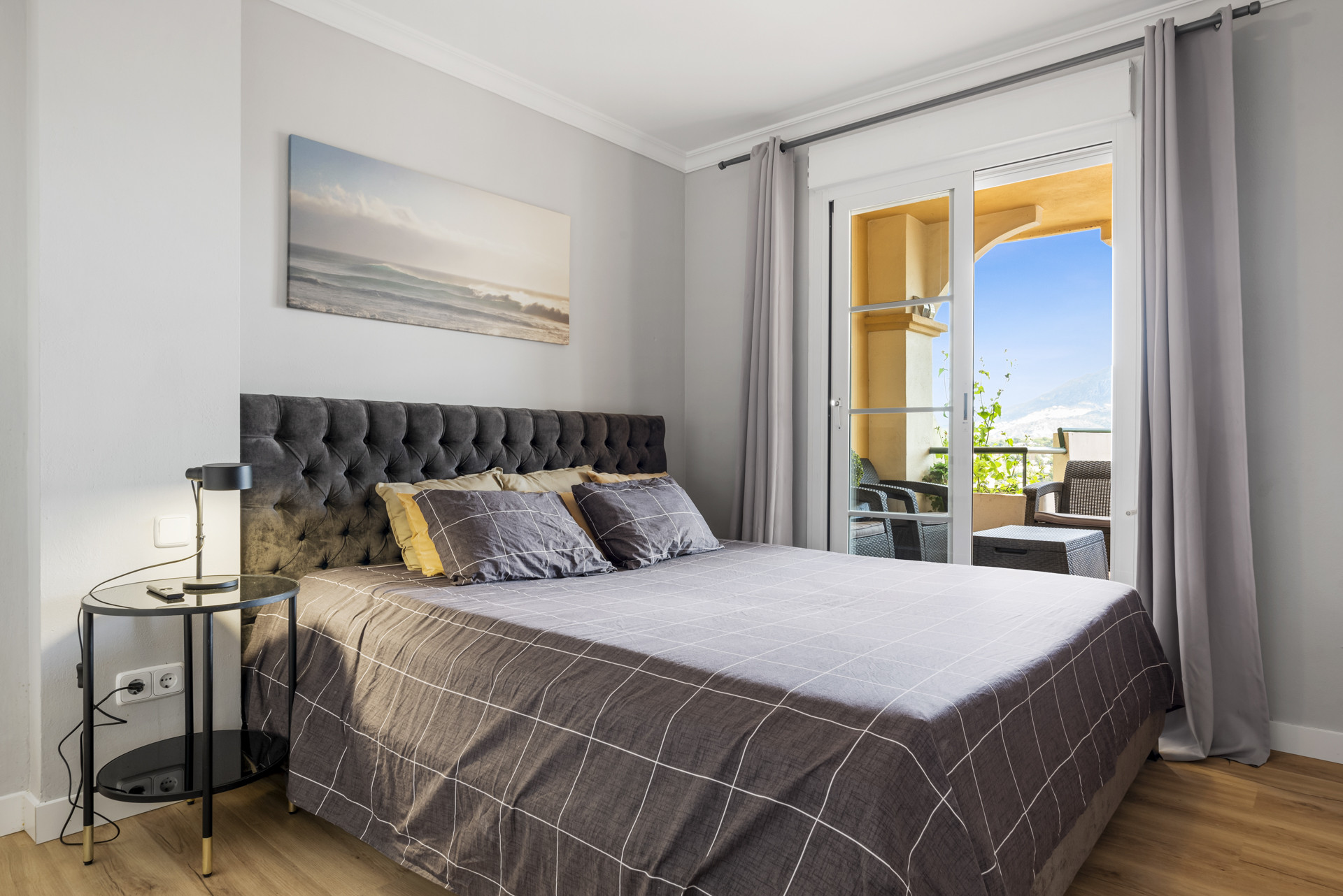 Bedroom featuring a bed, side table, and door to a balcony.