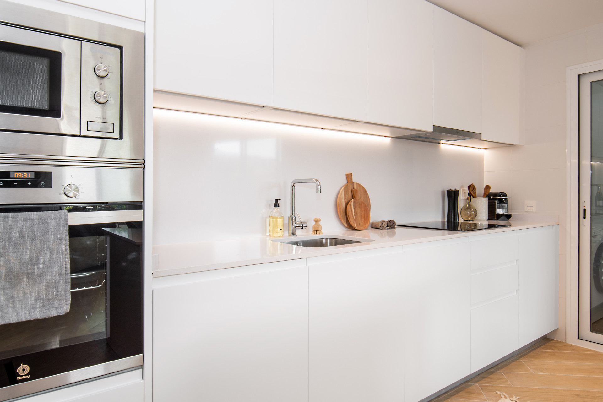 Modern kitchen with white cabinetry, stainless steel appliances, and a clean countertop layout.