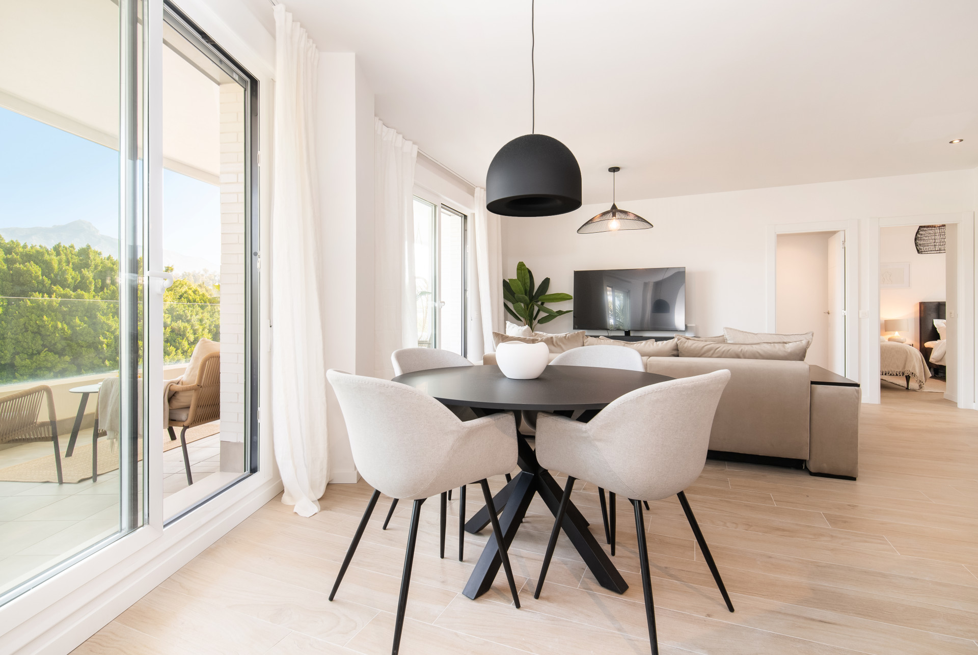 Dining area with a round table, stylish chairs, and a view of the terrace.