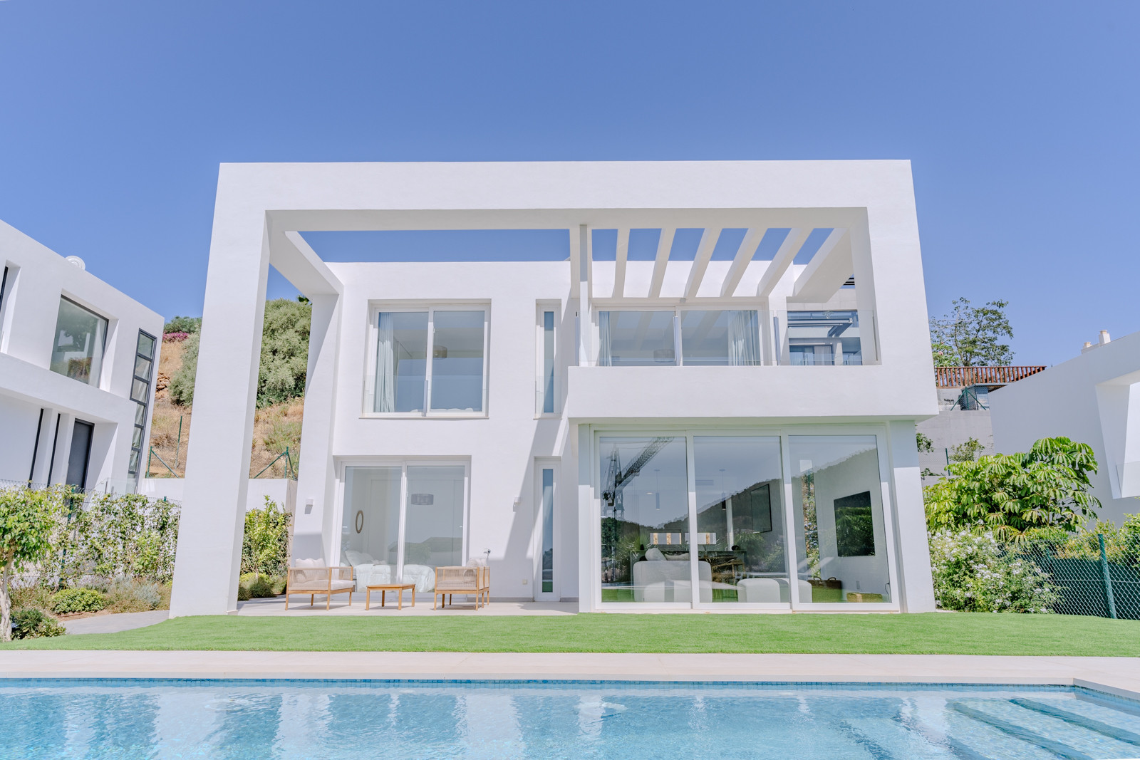 Exterior of a contemporary villa showcasing large glass windows and clean lines.